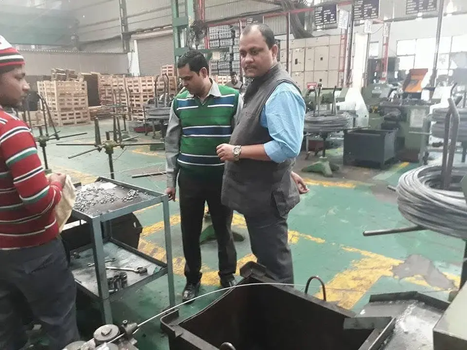 VMP team on the production floor beside heading machines and wire coils